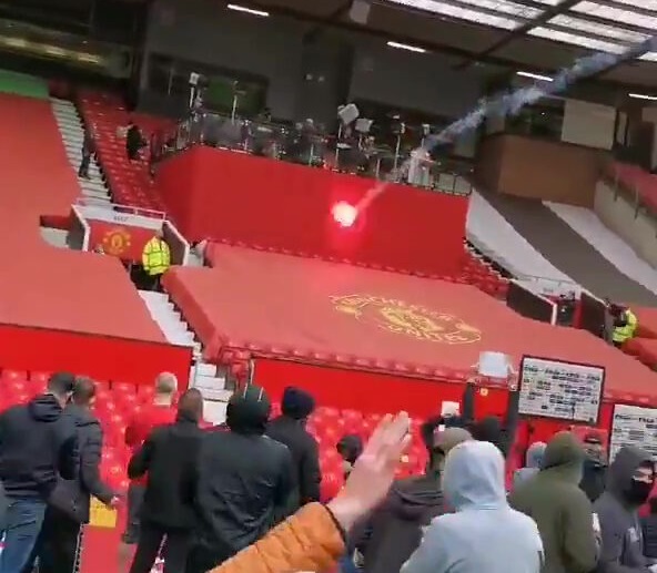 CĐV MU khiến các phóng viên phải che chắn trên sân Old Trafford