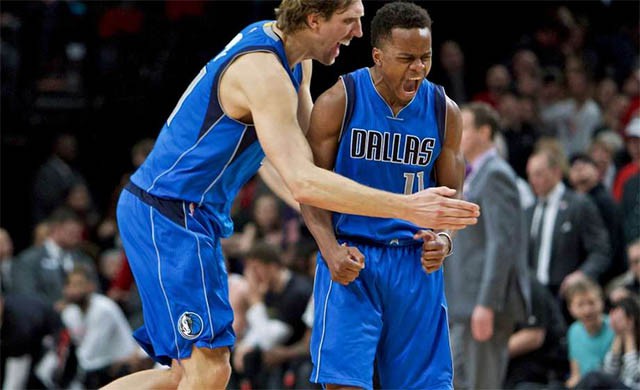 Yogi Ferrell nhận sự ch&uacute;c mừng của đồng đội, huyền thoại Dirk Nowitzki sau c&uacute; n&eacute;m 3 điểm quyết định th&agrave;nh c&ocirc;ng