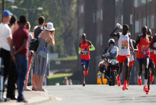Nhờ &yacute; ch&iacute;, Mo Farah (bọc tay m&agrave;u neon ph&iacute;a xa) vẫn b&aacute;m đuổi Kipchoge v&agrave; Kitata để lập KLQG mới