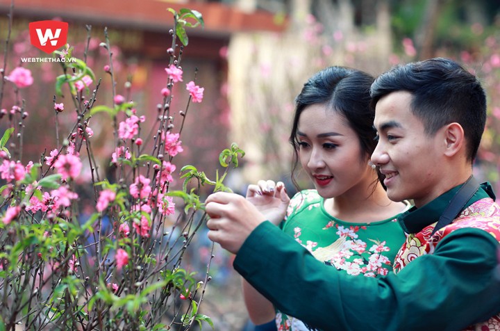 Những cành đào có hoa nở sắc hồng tưoi lại nhiều nụ và lộc đươc đôi bạn trẻ dừng lại ngắm nghía khá lâu Những cành đào có hoa nở sắc hồng tưoi lại nhiều nụ và lộc đươc đôi bạn trẻ dừng lại ngắm nghía khá lâu