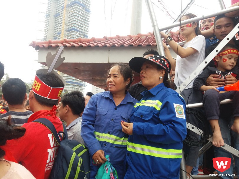Giữa biển người rợp đỏ đó, vẫn có những màu sắc ''lạc tông''. Chị Hoa (trái) và chị Thủy trong bộ đồng phục công ty khép nép một bên góc để cổ vũ cho thầy trò HLV Park Hang Seo. Ảnh: Trần Khánh Giữa biển người rợp đỏ đó, vẫn có những màu sắc ''lạc tông''. Chị Hoa (trái) và chị Thủy trong bộ đồng phục công ty khép nép một bên góc để cổ vũ cho thầy trò HLV Park Hang Seo. Ảnh: Trần Khánh